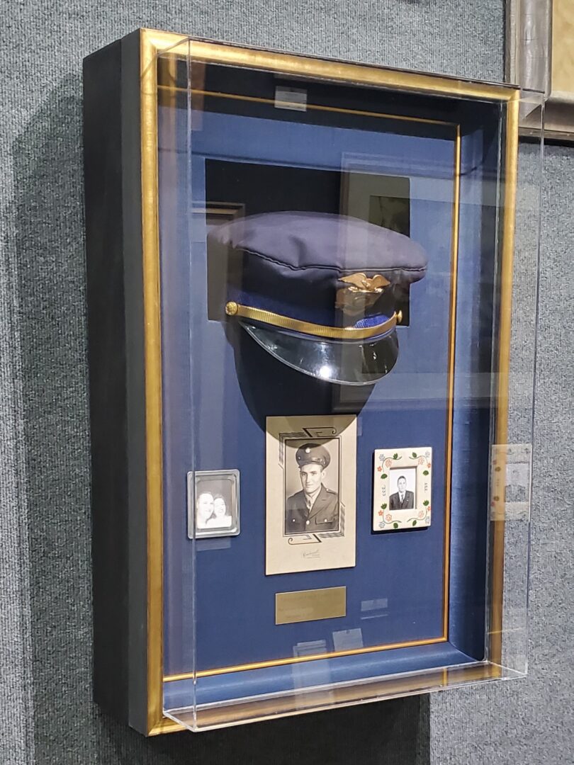 Police Officer (2) A framed hat case with a picture of a man in uniform.
