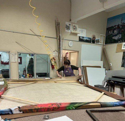 Gallery Stretching (2) A person in an art studio with some paintings